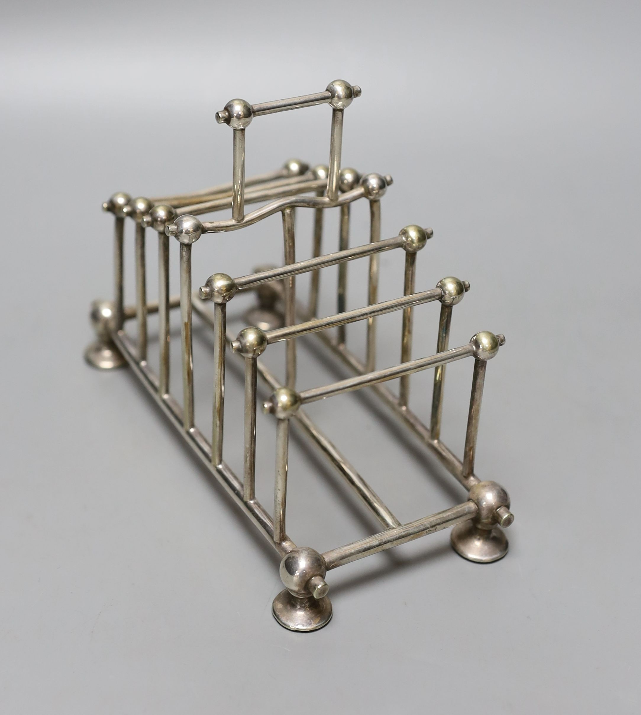 A late Victorian silver plated graduated seven bar toastrack, in the manner of Christopher Dresser, by William Hutton & Sons, length 16.4cm.